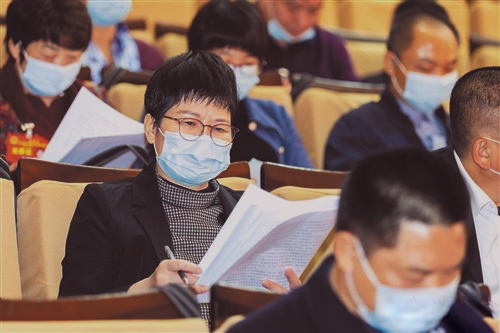 與會代表認真聆聽《政府工作報告》并做筆記