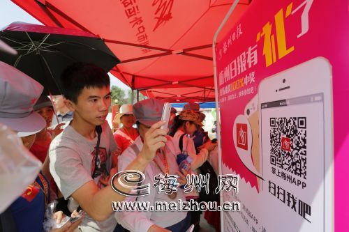 《梅州日報》對活動進行了直播，不少參加者在現(xiàn)場掃碼安裝“掌上梅州”APP，關(guān)注活動。