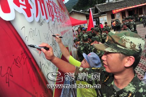 抵達終點多寶坑站，軍民在展板上簽名 。
